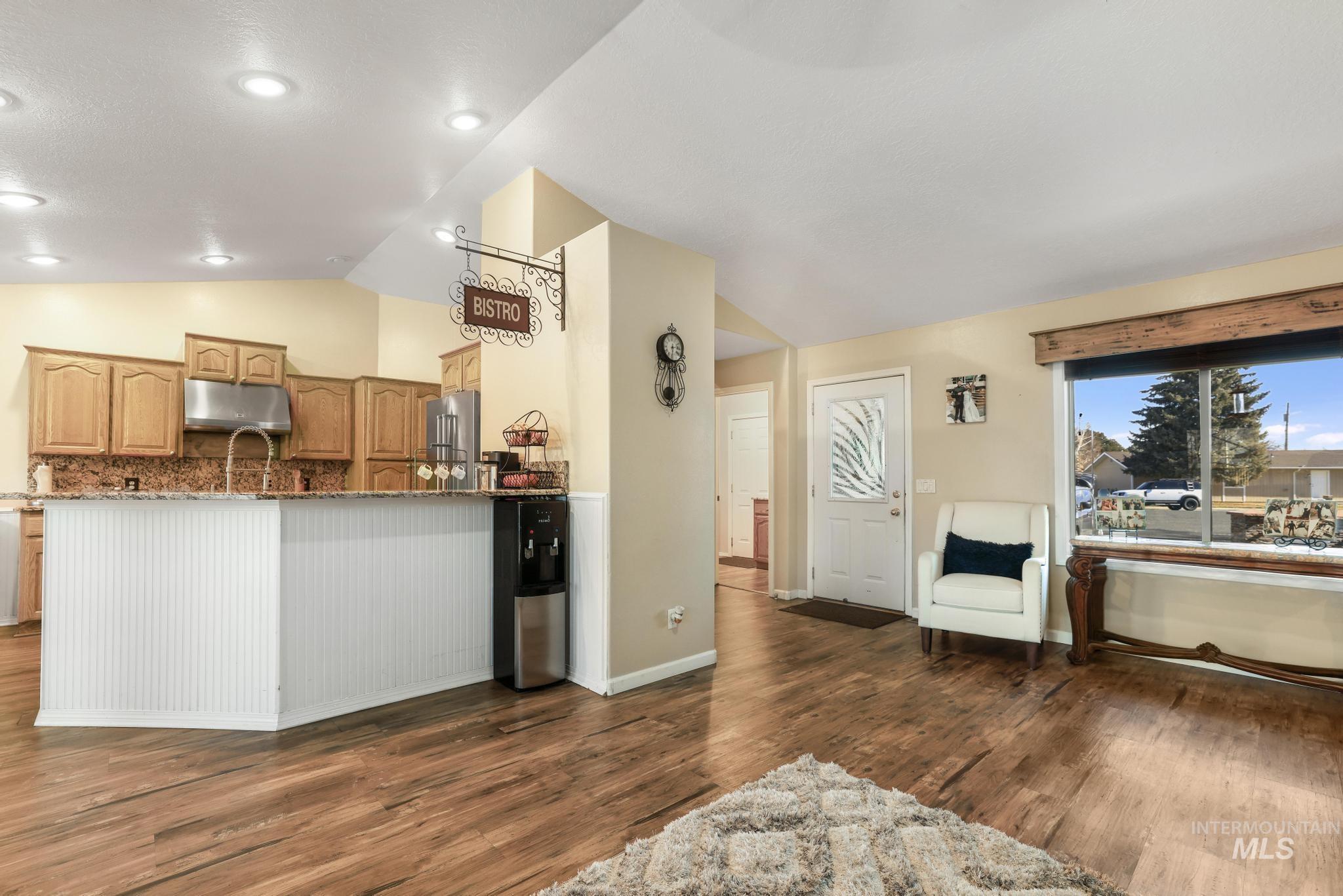 733 Beta Circle Twin Falls, ID 83301 - Photo 6 of 50 Kitchen featuring lofted ceiling, dark wood-style floors, dark stone countertops, wood finish cabinets, and high quality fridge