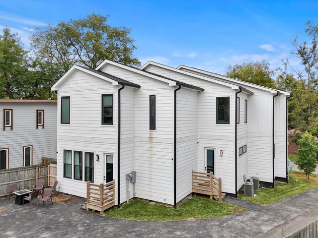 a view of a white house with a yard