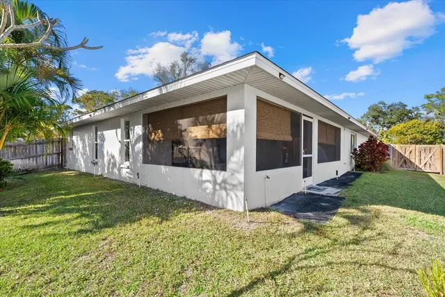 an aerial view of a house with a yard and large trees