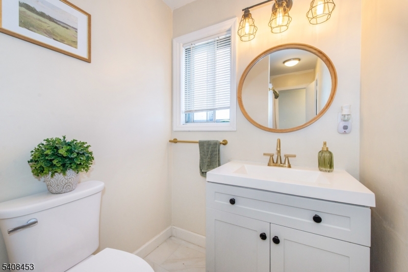 176 Harrison Road Parsippany, NJ 07054 - Photo 14 of 25 a bathroom with a toilet sink vanity and mirror