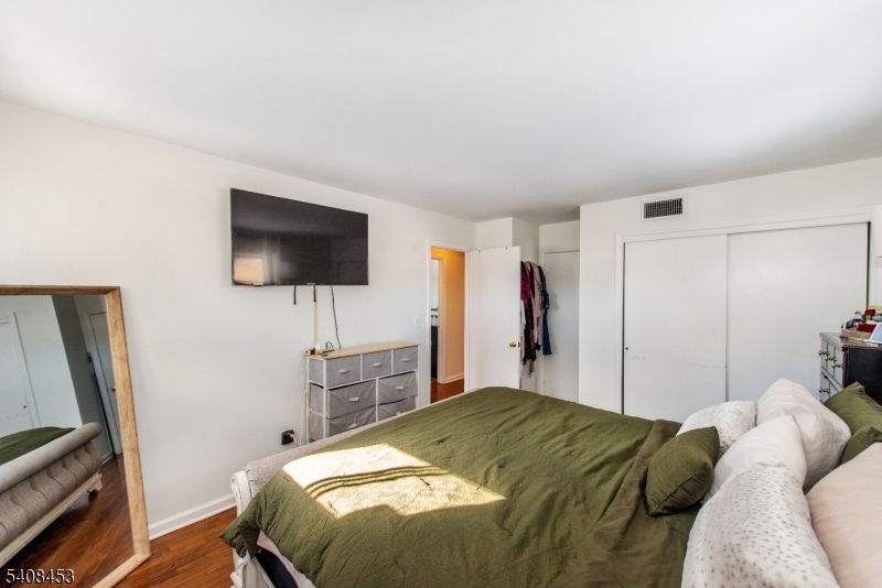 176 Harrison Road Parsippany, NJ 07054 - Photo 18 of 25 a bed sitting in a bedroom and a flat tv screen on wall