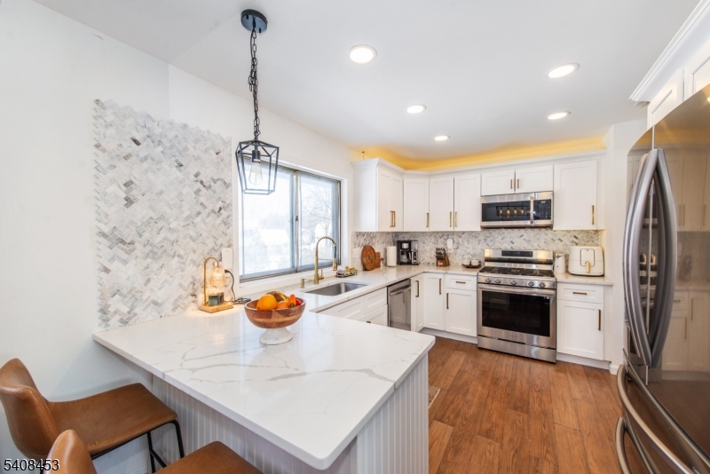176 Harrison Road Parsippany, NJ 07054 - Photo 4 of 25 a kitchen with stainless steel appliances granite countertop a sink a stove a refrigerator cabinets and chairs