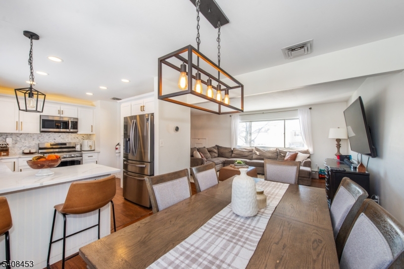 176 Harrison Road Parsippany, NJ 07054 - Photo 5 of 25 a living room with furniture a flat screen tv and kitchen view