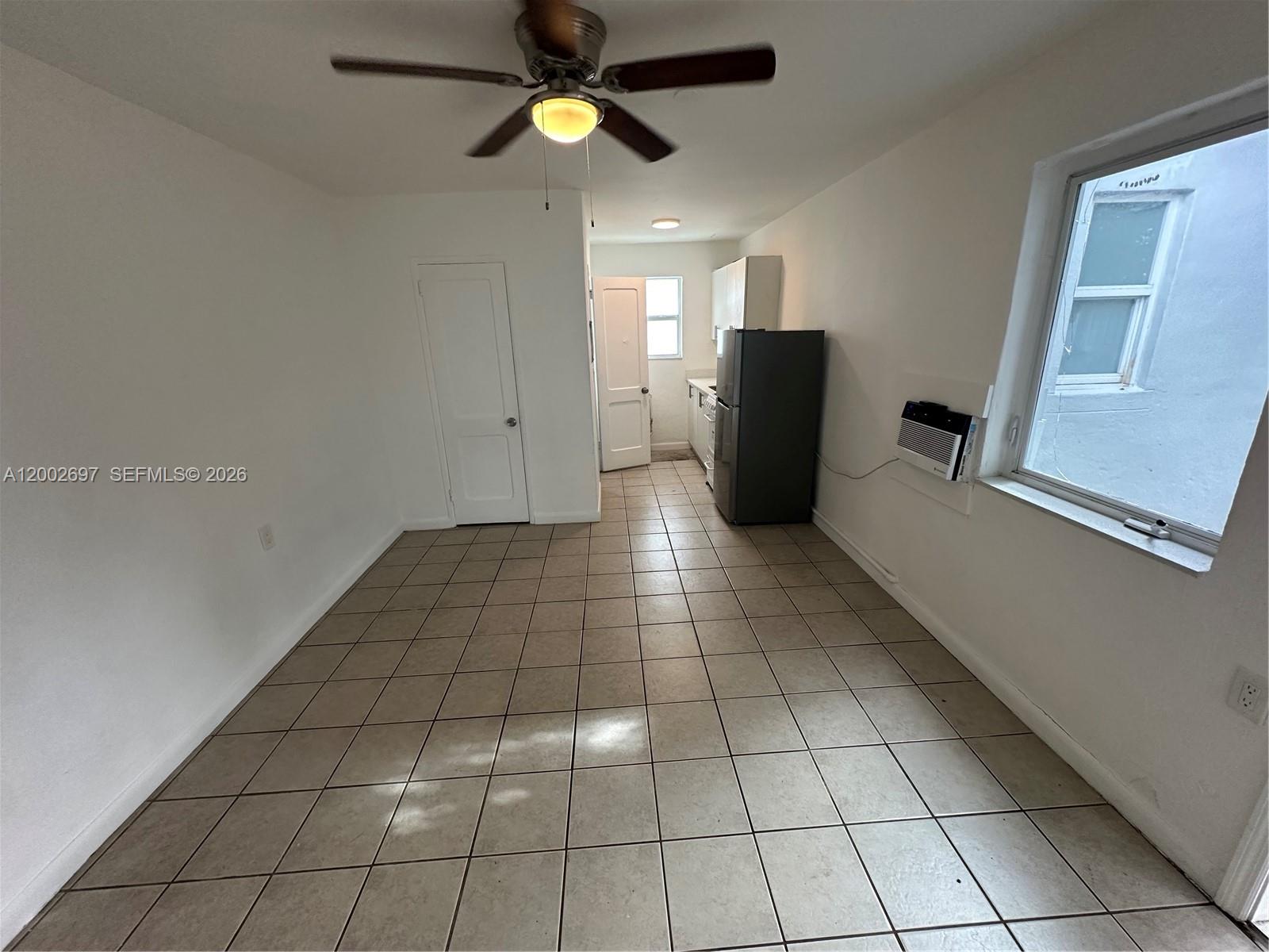 480 Southwest 10th Street, Unit 6 Miami, FL 33130 - Photo 2 of 7 a view of an empty room with window and wooden floor
