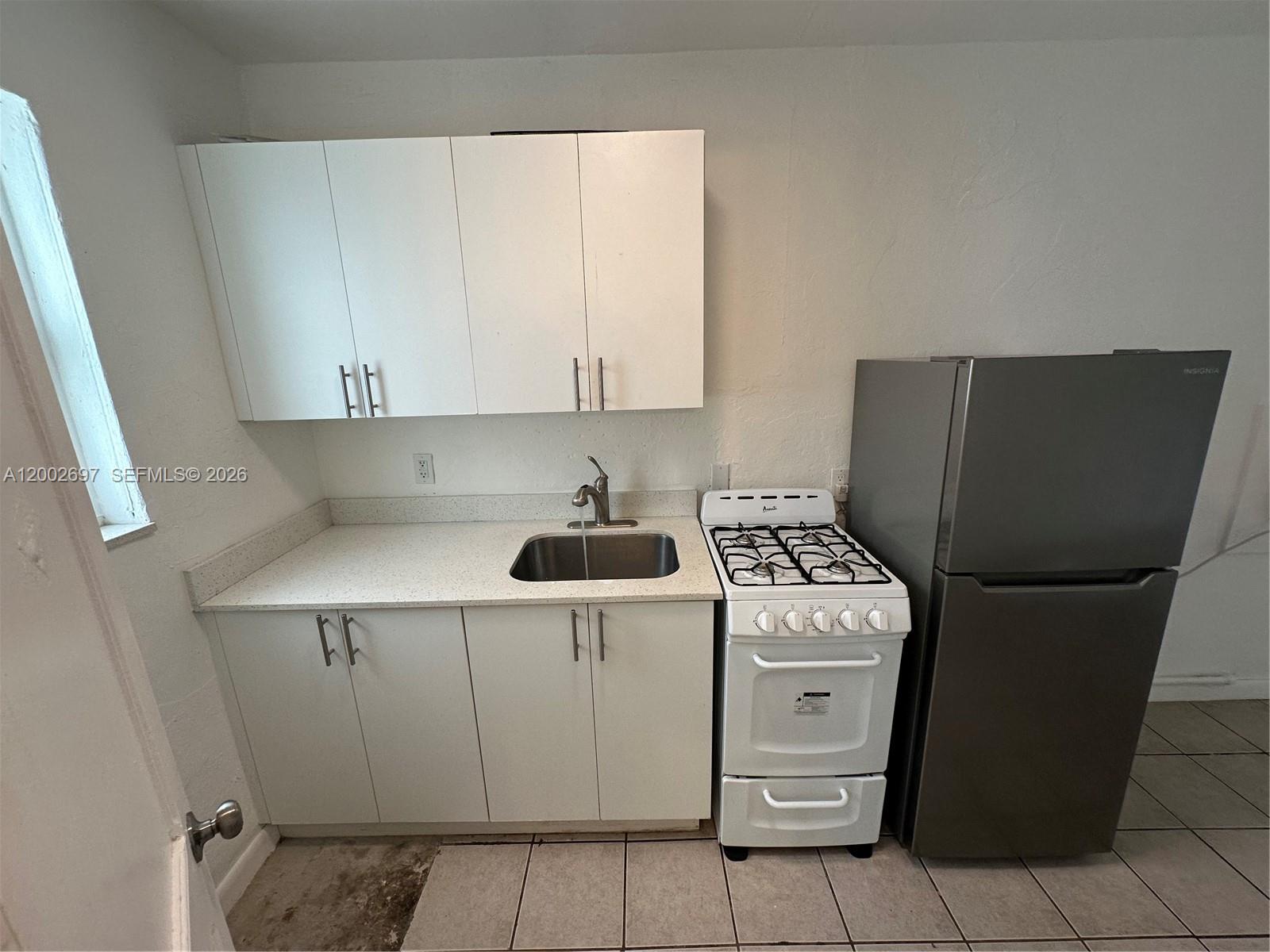 480 Southwest 10th Street, Unit 6 Miami, FL 33130 - Photo 3 of 7 a kitchen with a stove top oven and cabinets