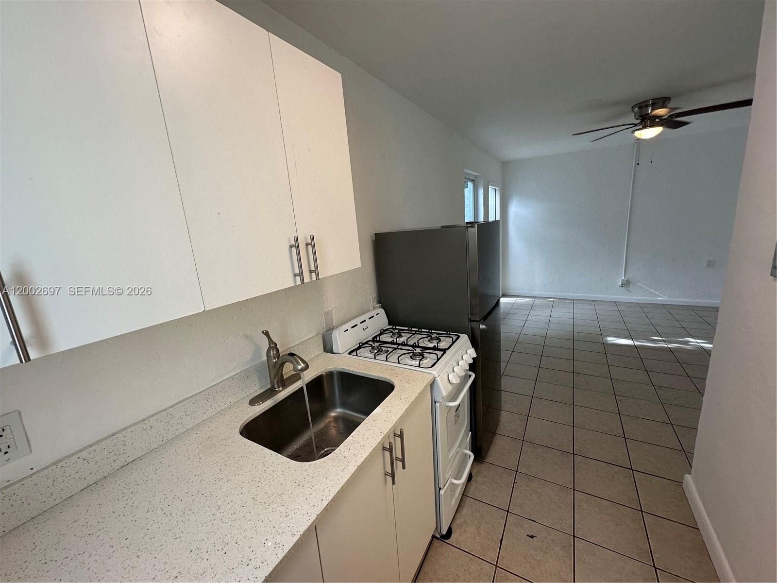 480 Southwest 10th Street, Unit 6 Miami, FL 33130 - Photo 4 of 7 a kitchen with a sink a stove and cabinets