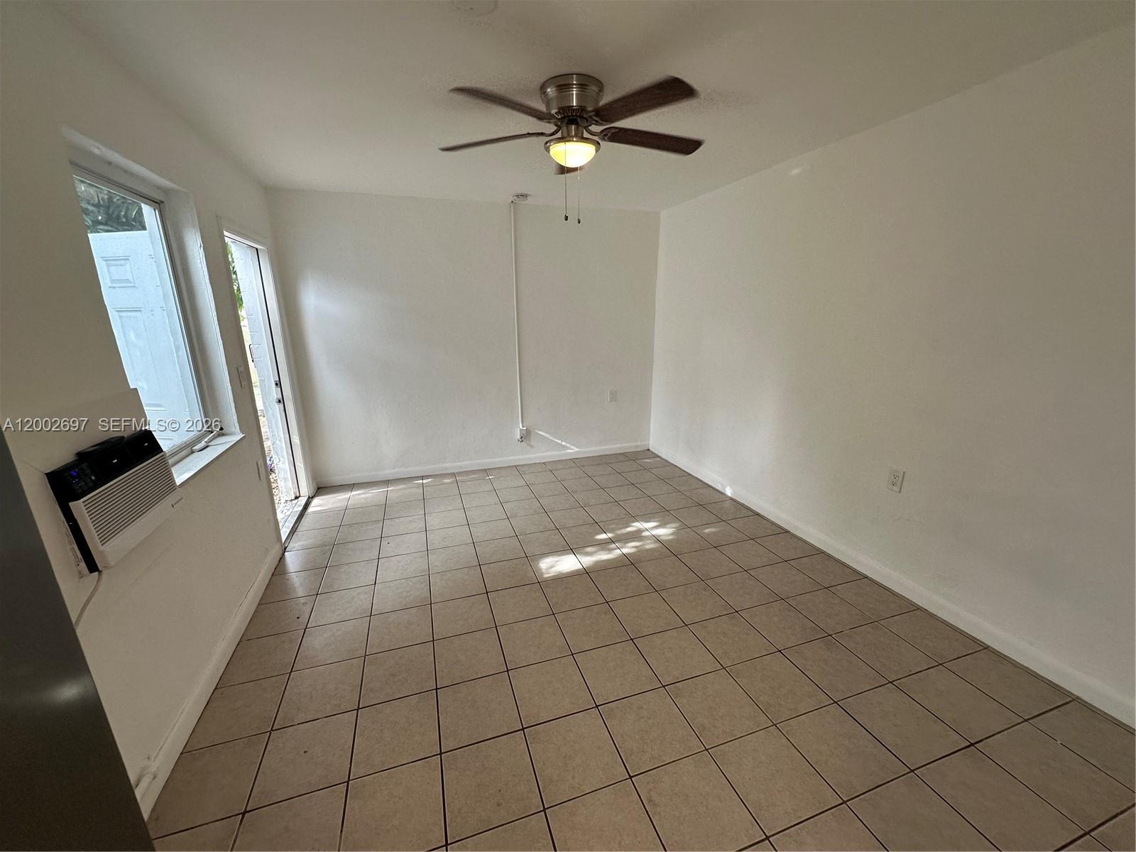 480 Southwest 10th Street, Unit 6 Miami, FL 33130 - Photo 5 of 7 an empty room with wooden floor and fan