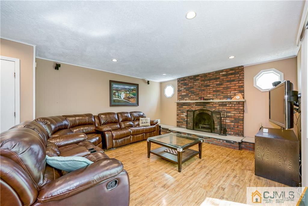 25 Timber Road East Brunswick, NJ 08816 - Photo 11 of 22 a living room with furniture a fireplace and a flat screen tv