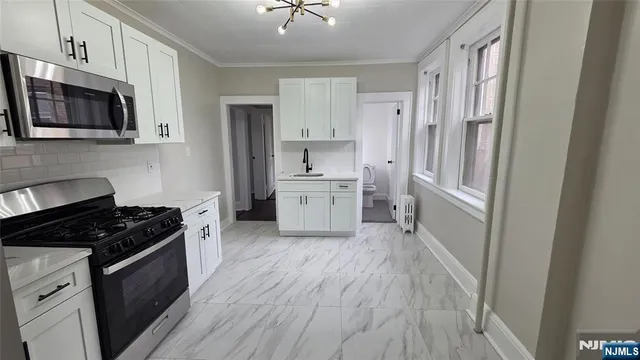 a kitchen with stainless steel appliances a refrigerator stove and sink