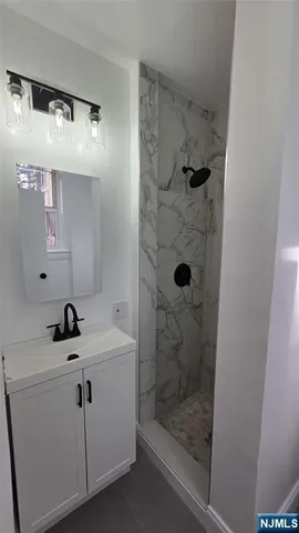 a bathroom with a sink a toilet a mirror and shower