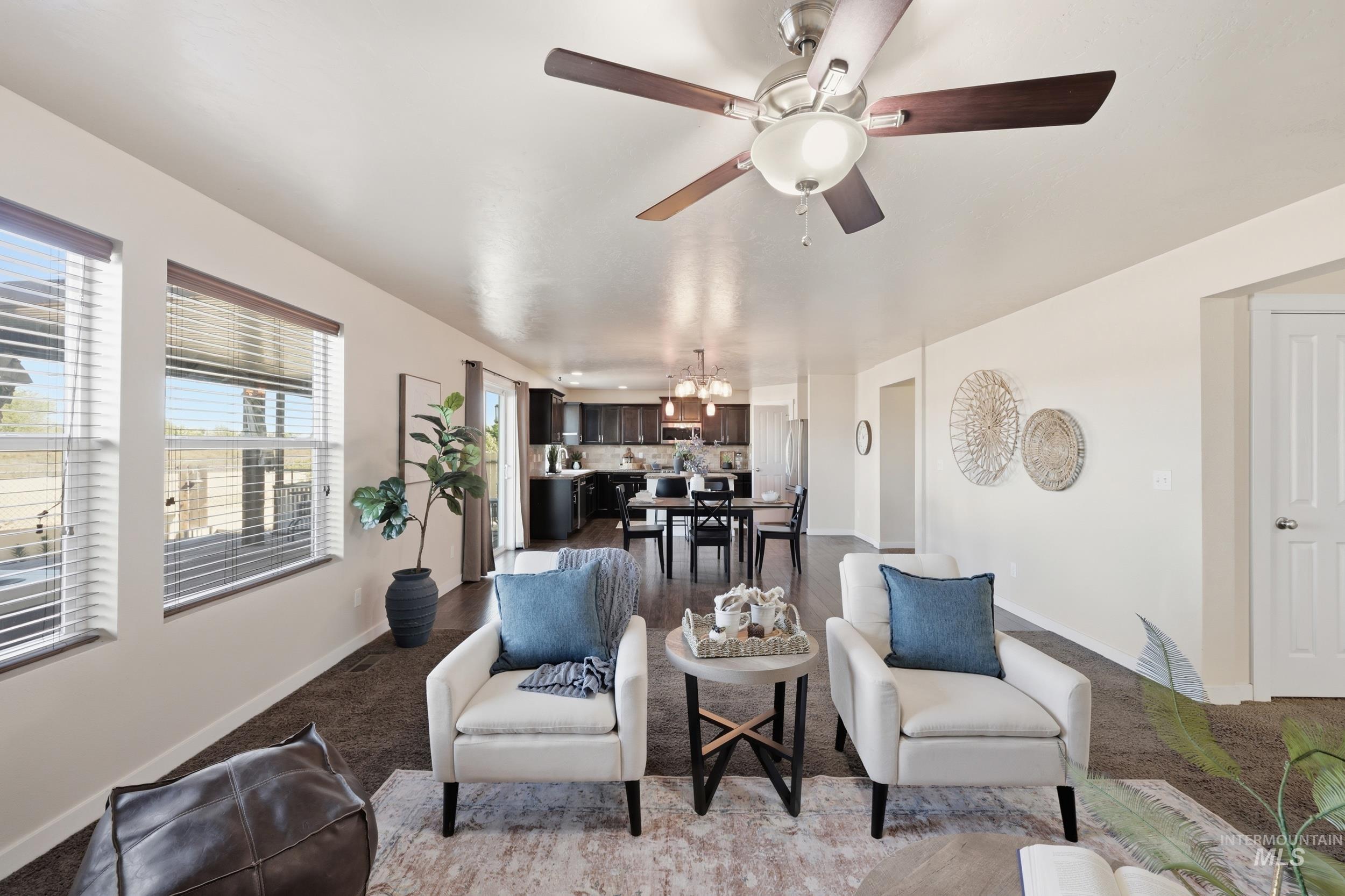 4855 South Chex Way Boise, ID 83709 - Photo 10 of 47 Open concept living area featuring a ceiling fan, multiple windows with blinds, and durable dark flooring