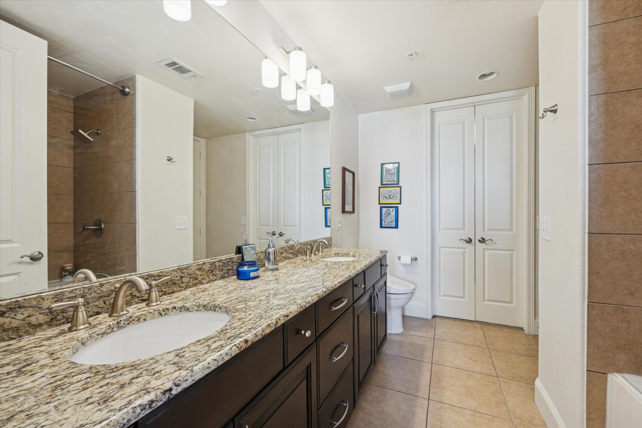 2120 Kipling Street, Unit 406 Houston, TX 77098 - Photo 14 of 19 a bathroom with a granite countertop double vanity sink a mirror and a shower