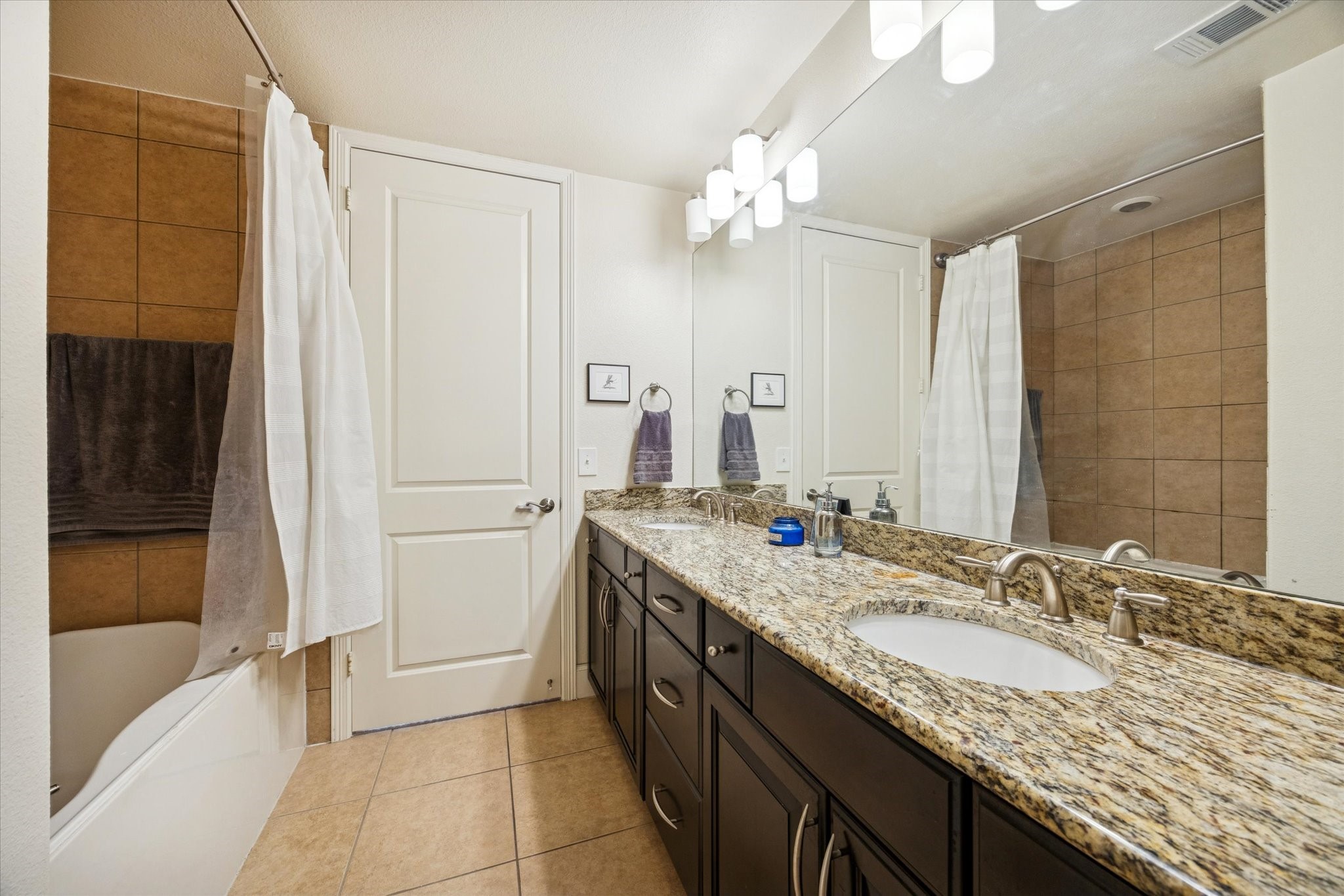 2120 Kipling Street, Unit 406 Houston, TX 77098 - Photo 15 of 19 a bathroom with a granite countertop sink a mirror and a bathtub