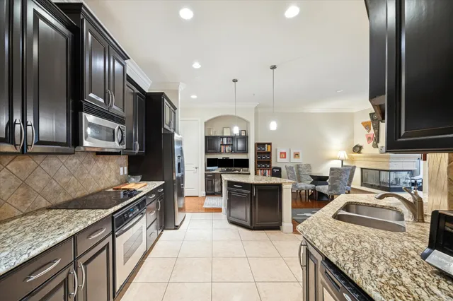 a kitchen with stainless steel appliances kitchen island granite countertop a refrigerator and a stove top oven