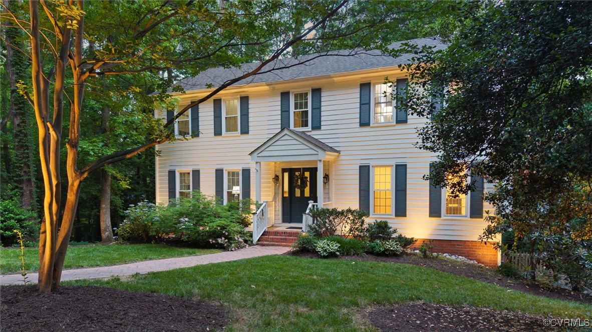 a front view of a house with a yard and trees