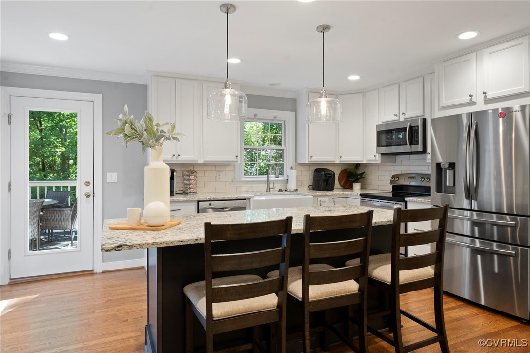 4107 Poplar Grove Road Midlothian, VA 23112 - Photo 30 of 38 a kitchen with stainless steel appliances granite countertop a stove a refrigerator a sink a dining table and chairs with wooden floor