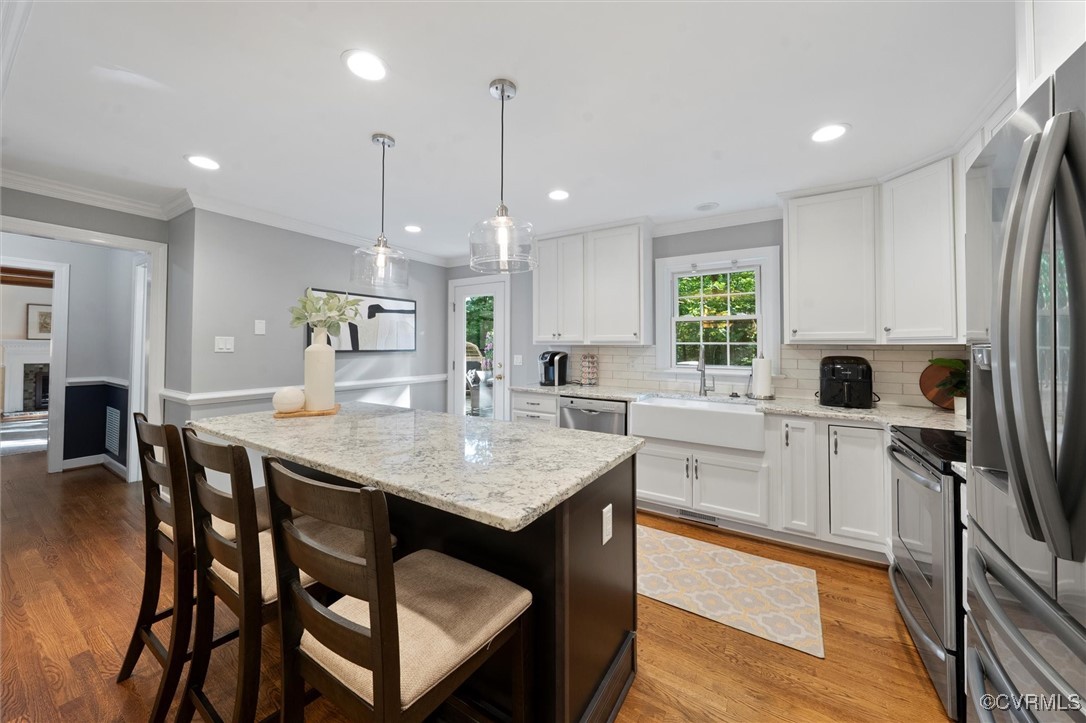 4107 Poplar Grove Road Midlothian, VA 23112 - Photo 31 of 38 a kitchen with stainless steel appliances granite countertop a stove top oven a refrigerator a sink and white cabinets with wooden floor
