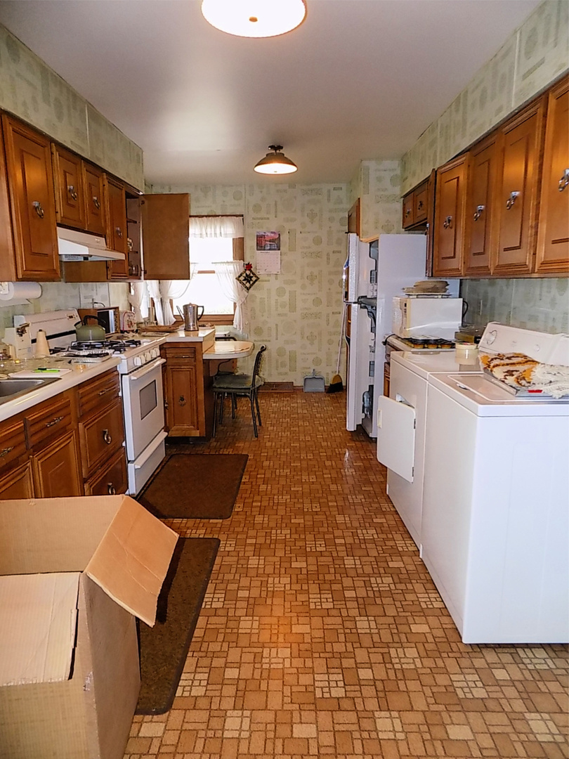 435 Sylvan Avenue Grand Ridge, IL 61325 - Photo 9 of 14 a kitchen with stainless steel appliances granite countertop a stove top oven a sink a dining table and chairs with wooden floor