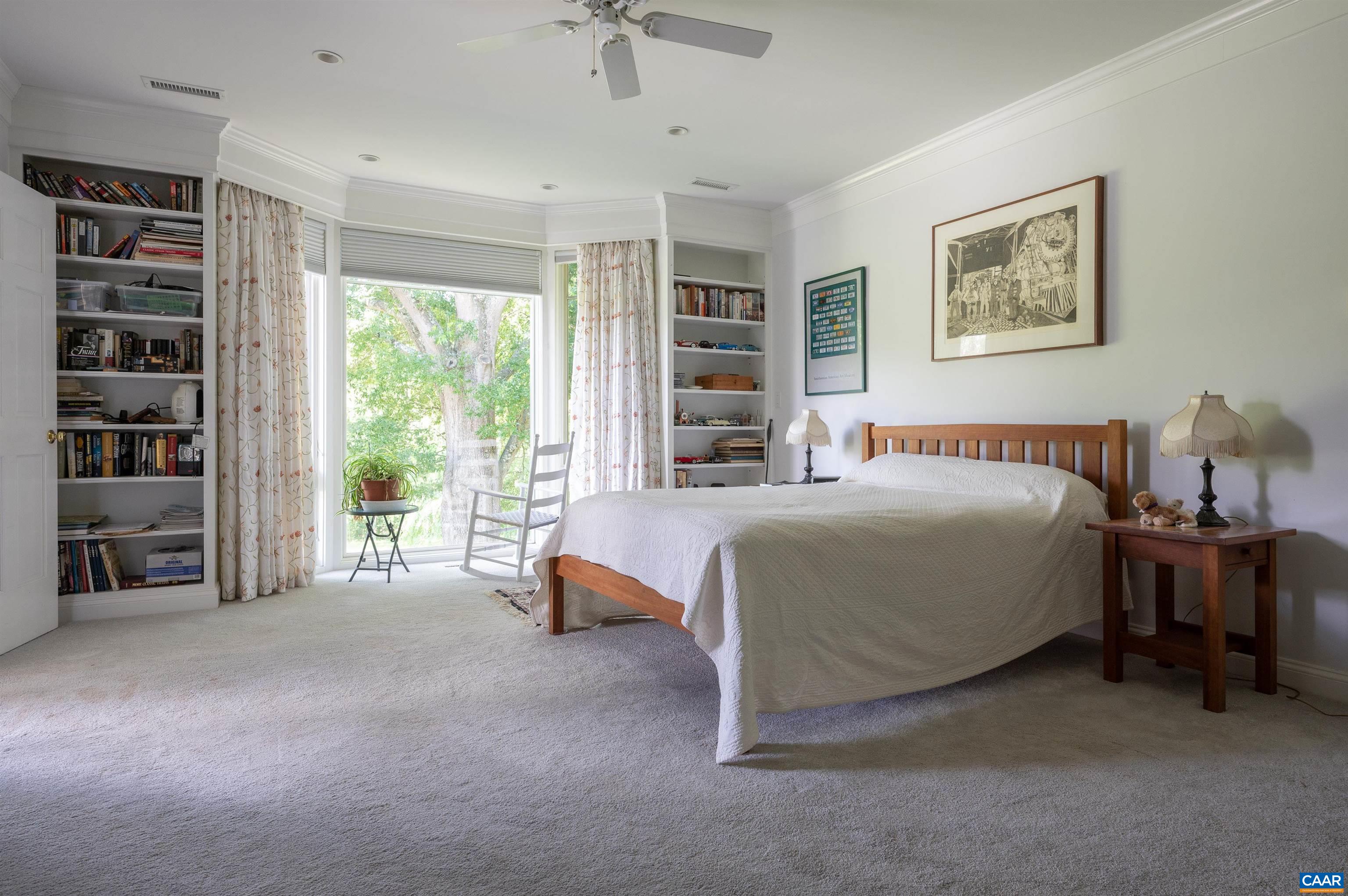 2845 Earlysville Road Earlysville, VA 22936 - Photo 19 of 35 a spacious bedroom with a bed a table and a large window