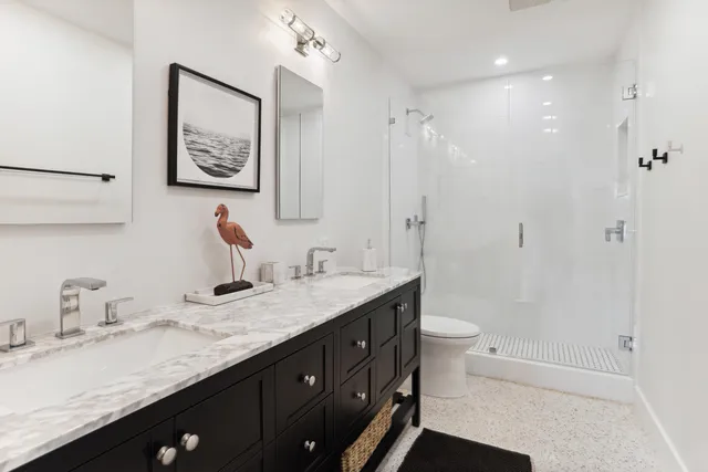 a bathroom with a granite countertop sink a toilet a shower and a mirror