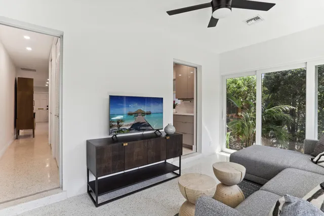 a living room with furniture a ceiling fan and a window
