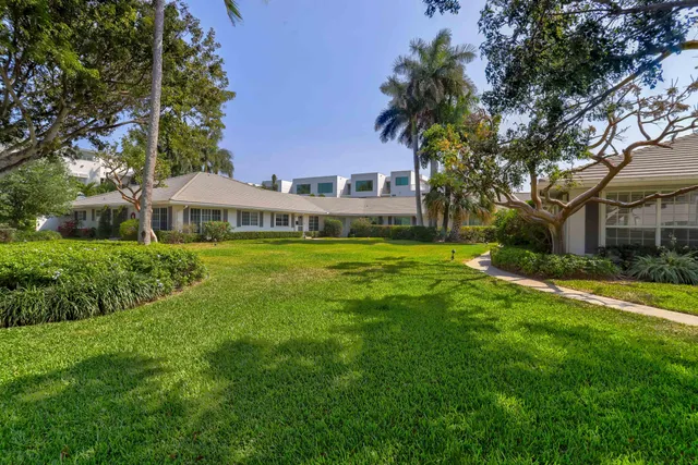 a view of a house with a big yard and large trees