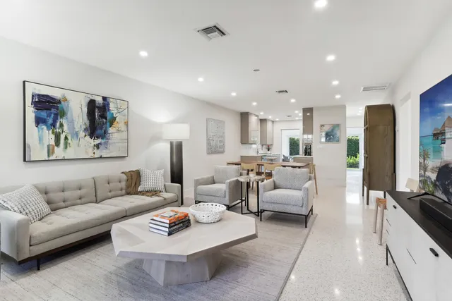 a living room with furniture and a dining table with kitchen view