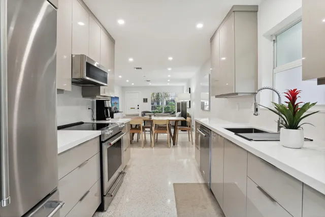 a kitchen with stainless steel appliances kitchen island granite countertop a sink a stove and cabinets