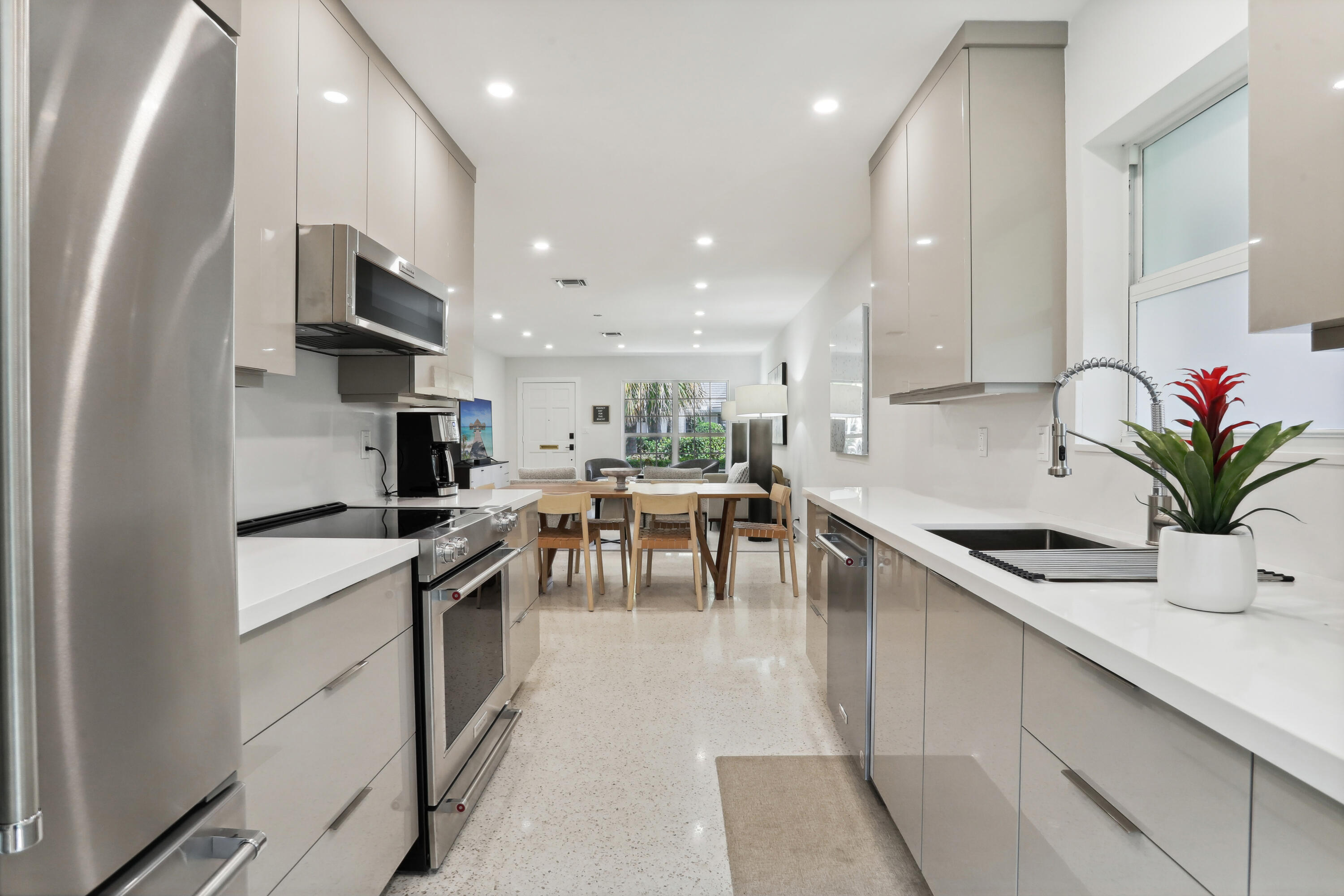 1004 Langer Way Delray Beach, FL 33483 - Photo 8 of 19 a kitchen with stainless steel appliances kitchen island granite countertop a sink a stove and cabinets
