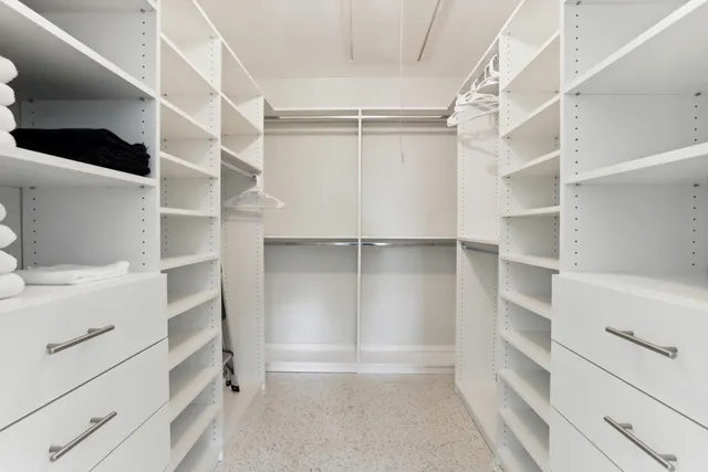 a view of walk in closet with empty racks