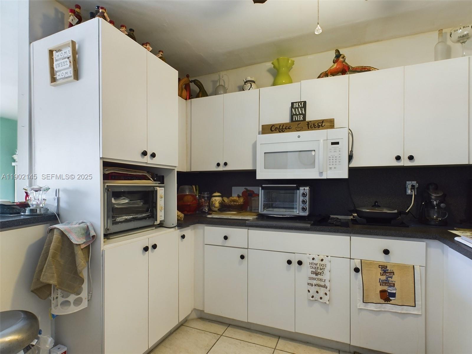 3861 Northwest 177th Street Miami Gardens, FL 33055 - Photo 12 of 15 a kitchen with granite countertop a stove a sink and a microwave