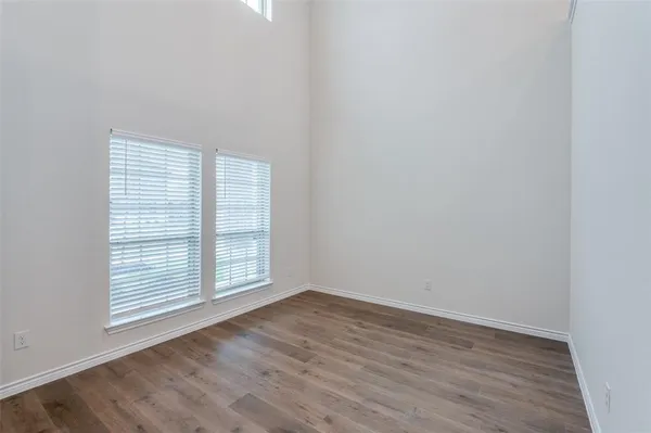an empty room with wooden floor and window