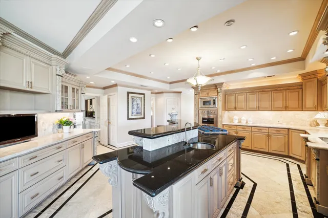 a kitchen with granite countertop a sink and white cabinets