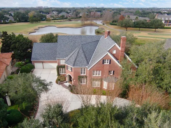 an aerial view of a house with a yard and lake view