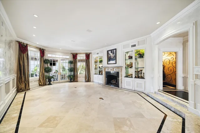 a large white room with large windows and a fireplace