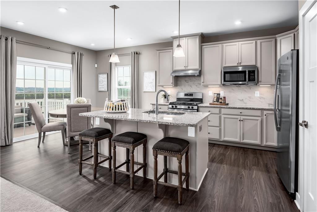 334 Dana Drive Eighty Four, PA 15330 - Photo 2 of 12 a kitchen with granite countertop a table chairs stove a sink dishwasher and cabinets with wooden floor