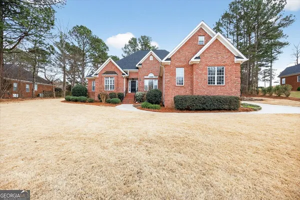 a front view of a house with a yard covered in snow