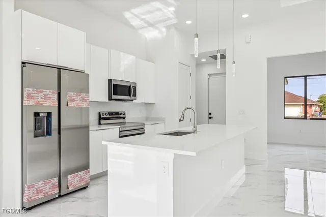 a kitchen with stainless steel appliances granite countertop a refrigerator and a sink