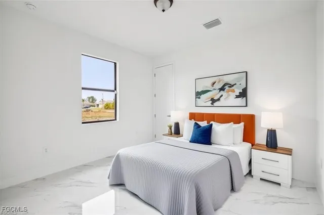 a bedroom with a bed and painting on the wall