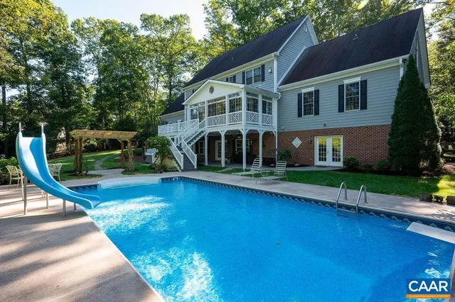 a view of house with swimming pool and garden