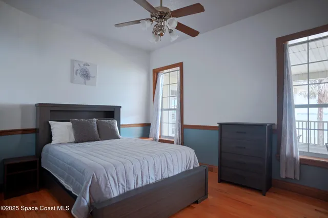 a large kitchen with stainless steel appliances wooden floor and a large window