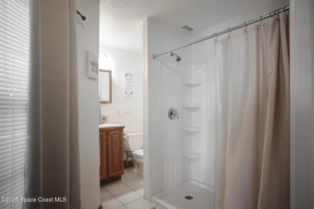 a bedroom with two large bed and a chandelier