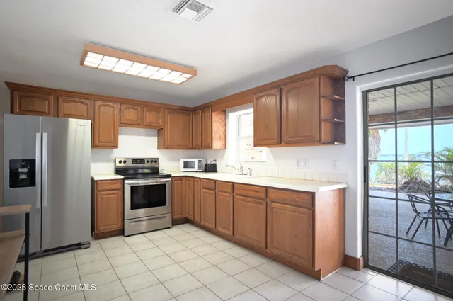 a living room with furniture a ceiling fan a lamp and a window