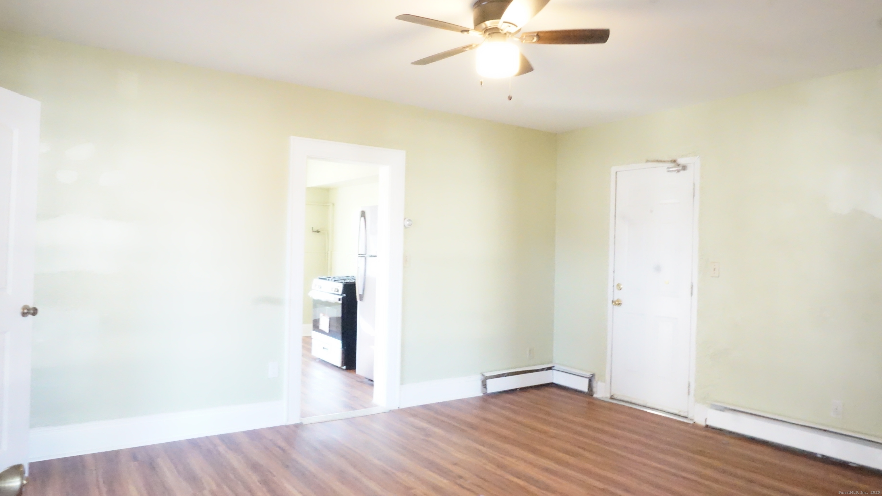 1621 Stratford Avenue, Unit 3 Stratford, CT 06615 - Photo 2 of 17 an empty room with wooden floor and door