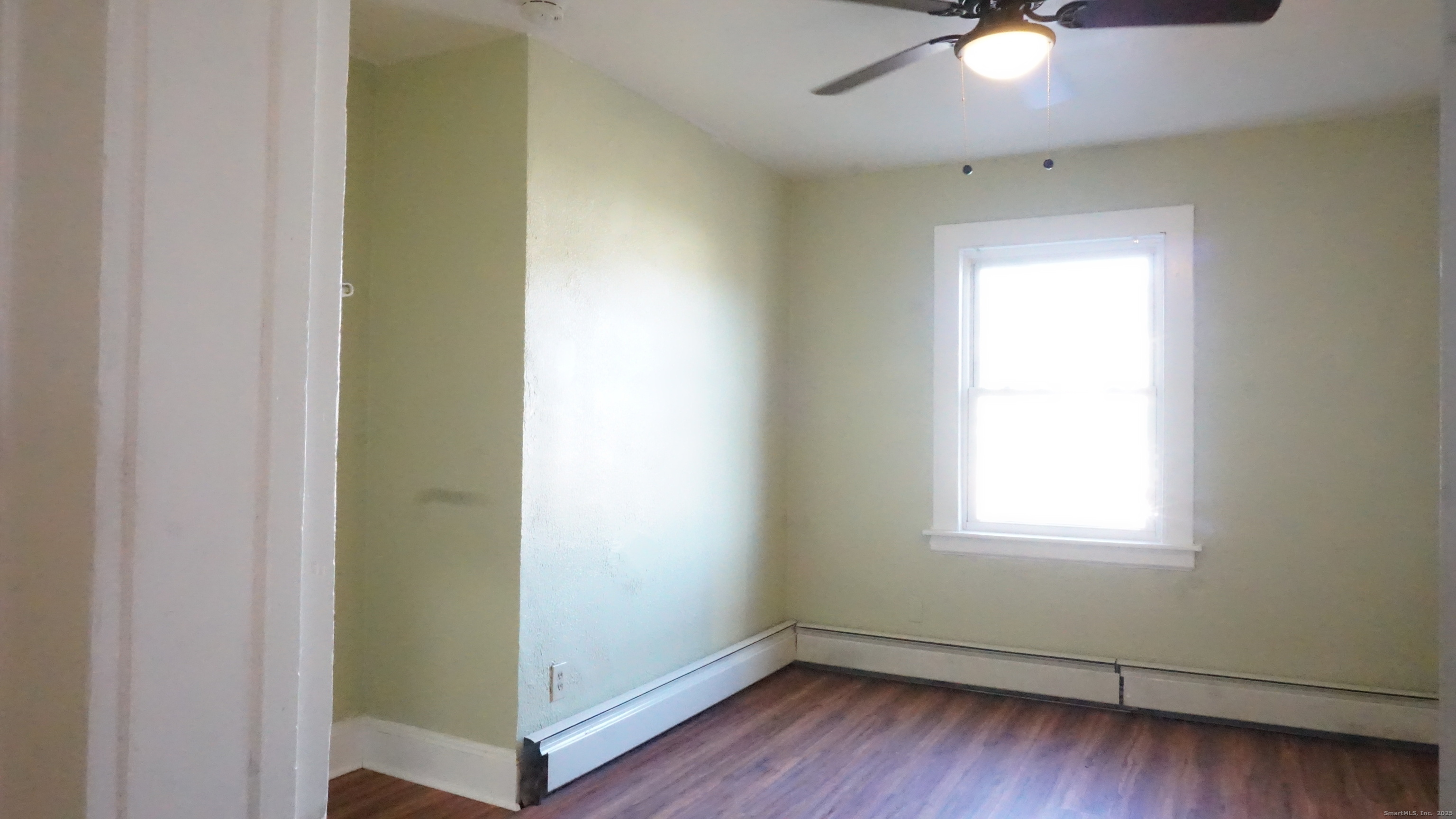 1621 Stratford Avenue, Unit 3 Stratford, CT 06615 - Photo 7 of 17 a view of an empty room with wooden floor and a window