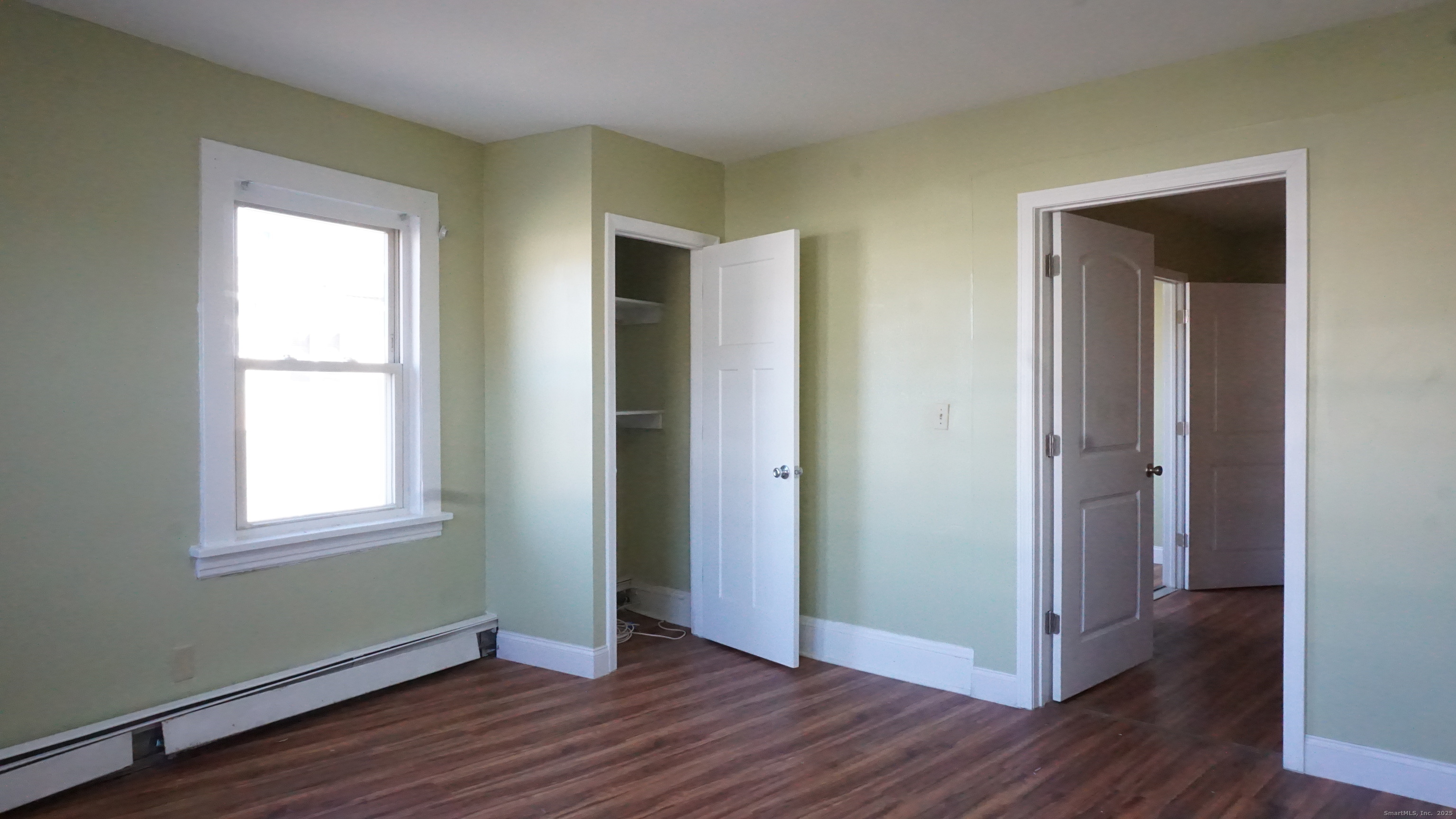 1621 Stratford Avenue, Unit 3 Stratford, CT 06615 - Photo 9 of 17 an empty room with wooden floor and windows