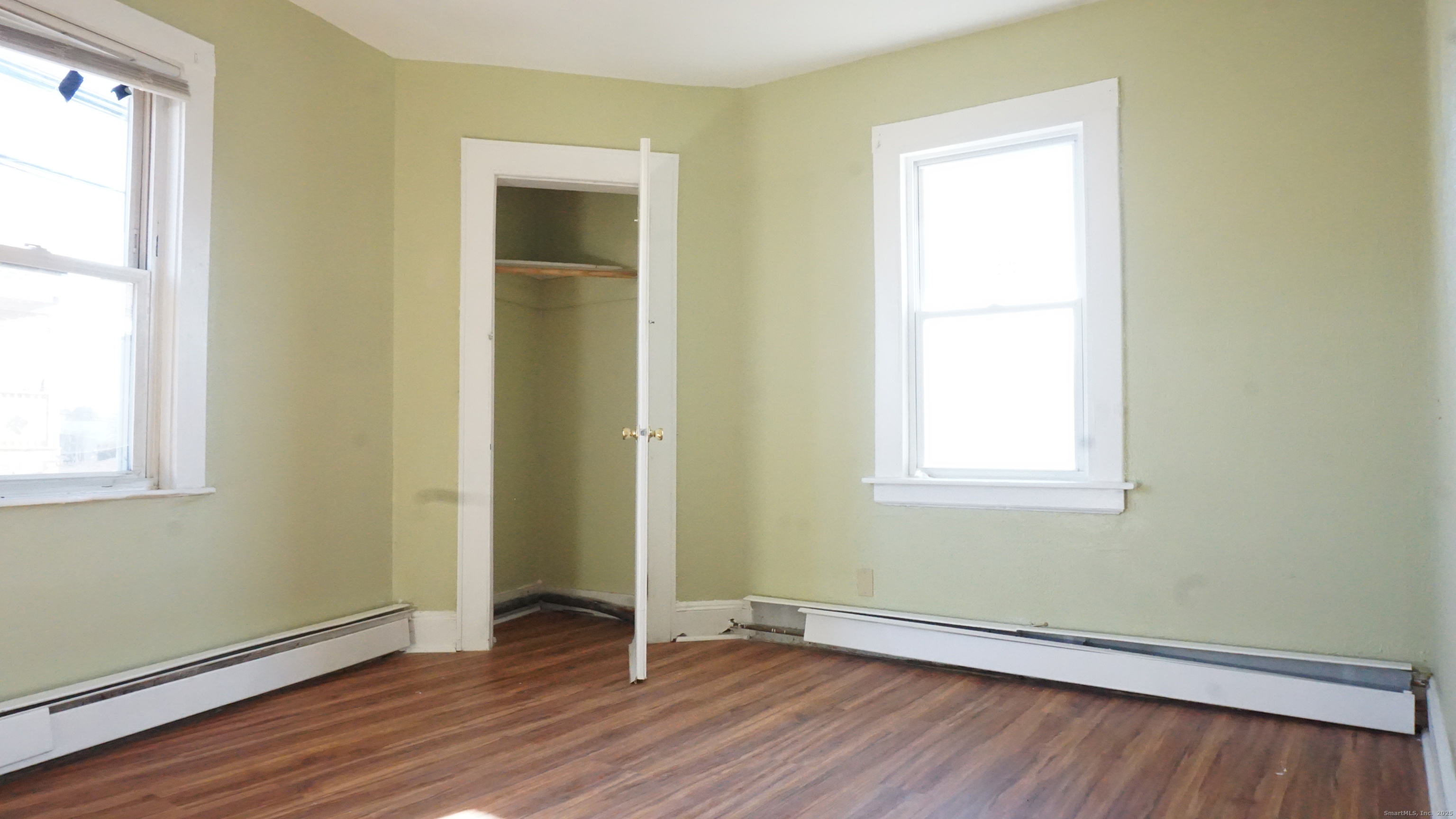 1621 Stratford Avenue, Unit 3 Stratford, CT 06615 - Photo 10 of 17 an empty room with wooden floor and windows