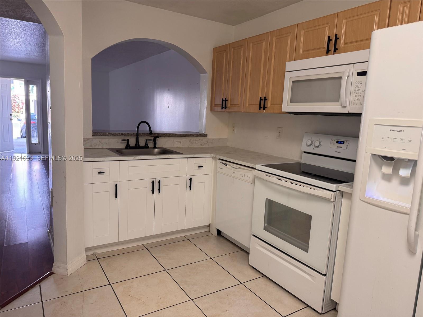 1260 Southeast 31st Court, Unit 10334 Homestead, FL 33035 - Photo 1 of 8 a kitchen with granite countertop white cabinets and white appliances