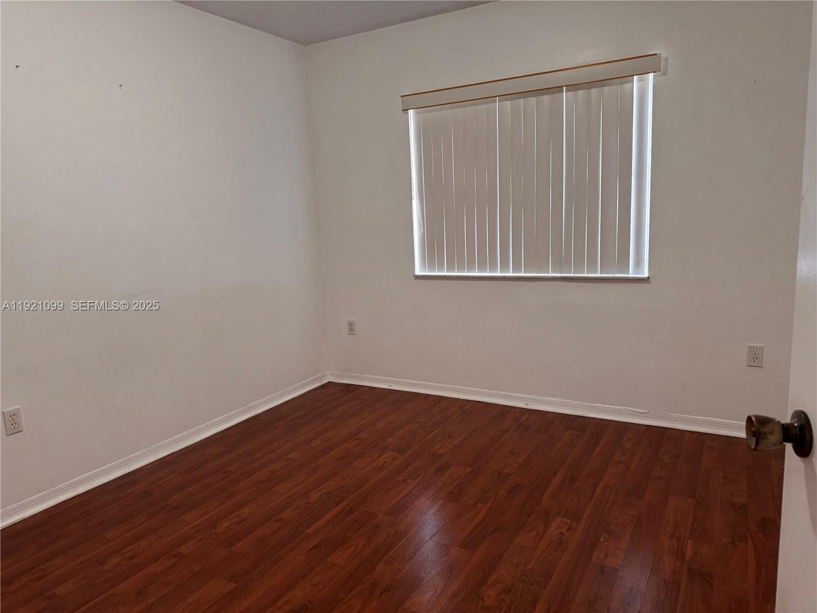 1260 Southeast 31st Court, Unit 10334 Homestead, FL 33035 - Photo 8 of 8 a view of an empty room with wooden floor and a window