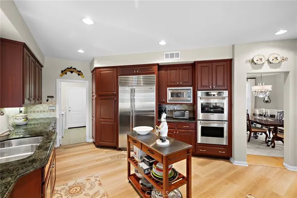 a kitchen with stainless steel appliances granite countertop a refrigerator and a stove top oven